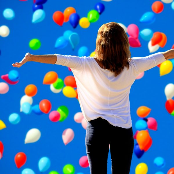 Imagen positiva de una mujer entre globos de colores
